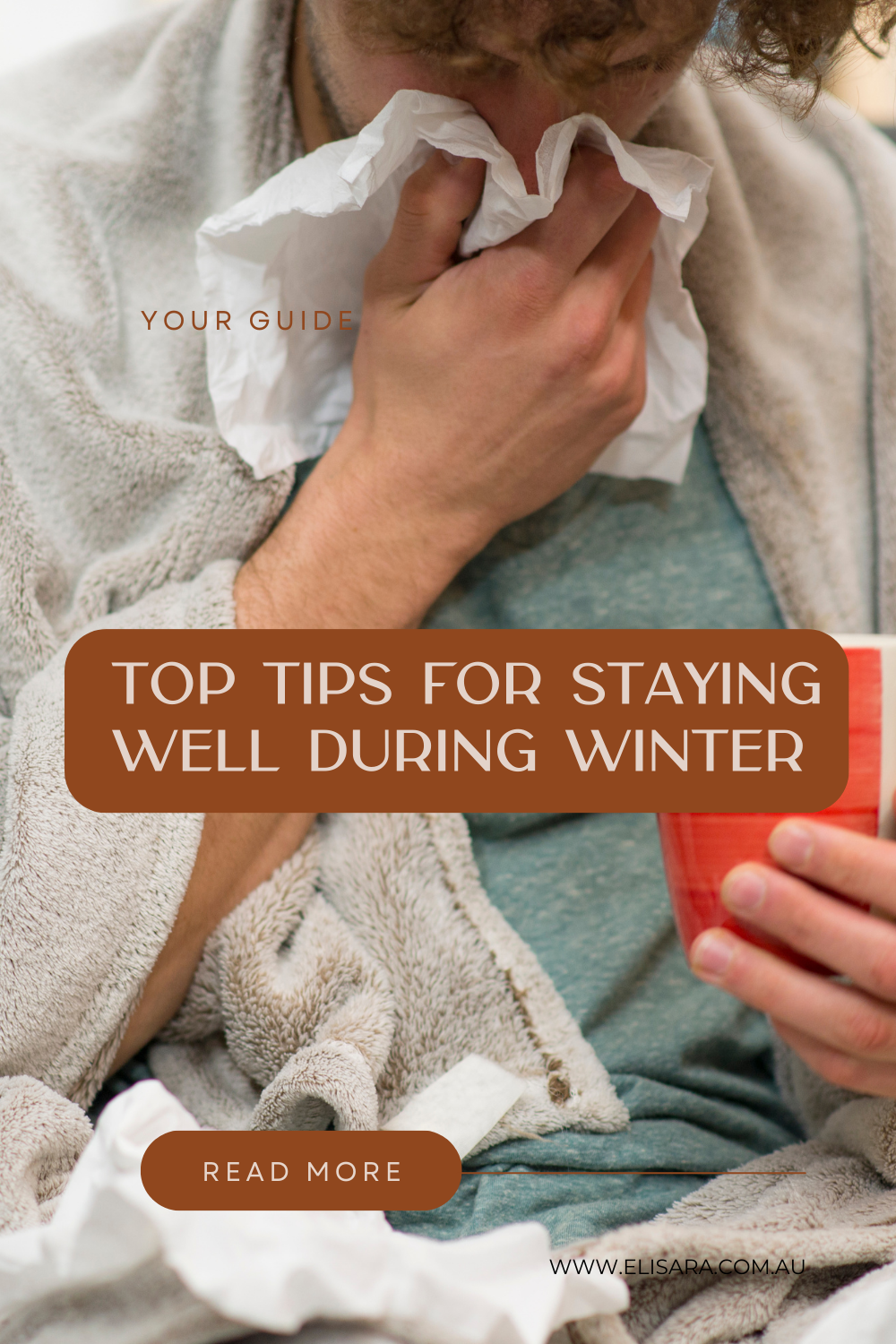 Image of a man in a white dressing gown sitting down using a tissue or hankie on his nose due to a cold. He is holding a red cup of tea and the caption over the top says "Top tips for staying well during winter".